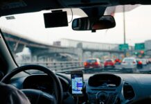 LEX Uber – regulacja prawna świadczenia usług przewozowych Wnętrze auta z kierowcą korzystającym z nawigacji na telefonie.