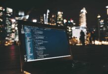 Ulga B+R czyli cash-back dla start-upów lub niższy podatek dla pozostałych laptop z kodem programu na ekranie na tle rozświetlonego miasta nocą