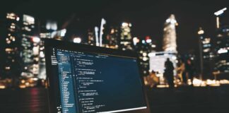 Ulga B+R czyli cash-back dla start-upów lub niższy podatek dla pozostałych laptop z kodem programu na ekranie na tle rozświetlonego miasta nocą